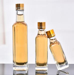 China Glass Olive Oil Bottle 100ml 250ml 500ml Round Clear Cooking Oil Bottle with Cap on sale